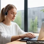 한글 입력 방식의 변화 - A modern Scandinavian workspace scene featuring a young adult woman using voice dictation on her sle...